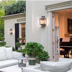 a white couch sitting on top of a patio next to a table with a potted plant