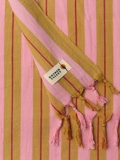 a pink and yellow striped scarf with tassels