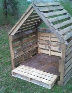 a dog house made out of wooden pallets