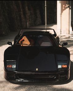 a black sports car parked in front of a building