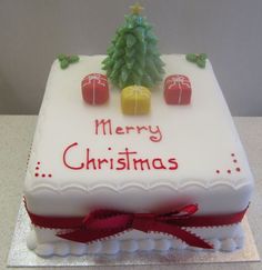 a white cake with red ribbon and decorations on it