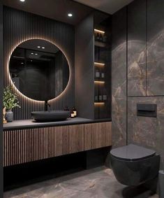 a bathroom with a round mirror and black counter top in front of a marble wall