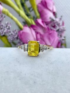 PRODUCT DESCRIPTION: Ring Information: Type: Statement Ring Fit: Comfort Metal: 925 Sterling Silver Plating: Vermeil Yellow Gold Total Stone Weight (ct.):  1.3 Product Weight:  2.63 grams Number of 7 x 5 mm Faceted Cut Yellow Sapphire:  1 Minimum Total Weight (ct.):  0.74 Average Color:  Yellow Average Clarity:  I2 Enhancement: Natural Setting Type:  Prong Number of 1.5 x .75 x .38 mm Taper Baguette Faceted Cut White Diamonds:  18  Minimum Total Weight (ct.):  .10 Average Color:  Colorless Avera Gia Certified Classic Yellow Diamond Ring, Yellow Diamond Ring With Emerald Cut Center Stone, Anniversary Yellow Sapphire Ring Brilliant Cut, Yellow Diamond Ring In 14k Gold, 14k Gold Yellow Diamond Ring, Yellow 14k Gold Diamond Ring, Yellow Diamond Baguette Cut Jewelry, Yellow Sapphire Ring With Prong Setting And Round Cut, Yellow Sapphire Ring With Round Cut Gemstone