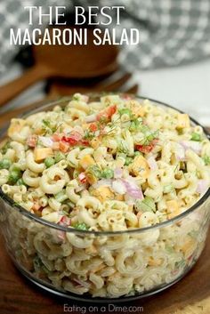 a bowl filled with macaroni salad on top of a wooden table