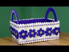 a purple and white basket sitting on top of a wooden table