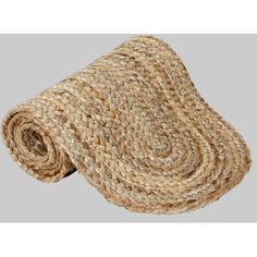 a roll of jute rug on a gray background with the end rolled up to show it's natural texture