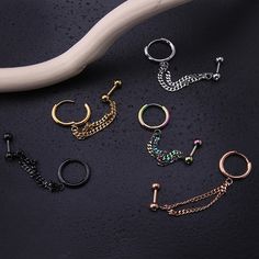 several different types of rings and chains on a black surface next to a white handle