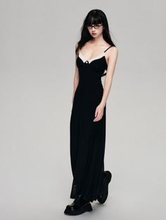 a woman in a long black dress is standing