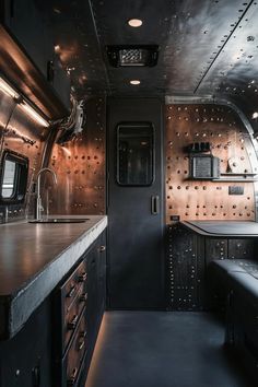 the interior of an rv with stainless steel cabinets and counter tops, along with black counters