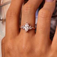 a woman's hand with an engagement ring on her finger, and the other hand holding