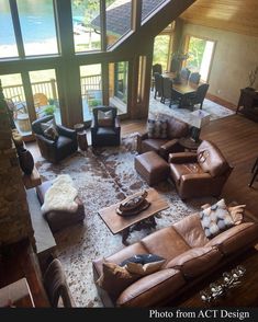 an aerial view of a living room with couches, chairs and tables in front of large windows