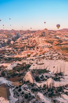 many hot air balloons flying over the rocky terrain in cappad national park, california