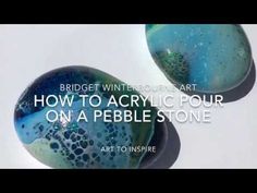 two marbles with the words how to acrylic pour on a pebble stone