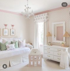 a bedroom with pink walls and white furniture in the room, including a doll house