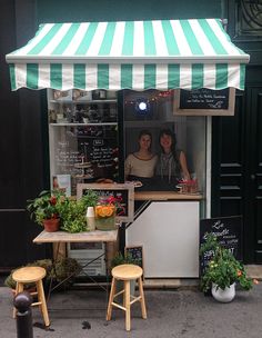 an outdoor cafe with two women behind the counter