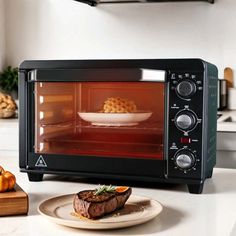 a toaster oven sitting on top of a counter next to a plate with food in it