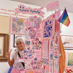 a woman standing in front of a pink display with lots of stickers on it