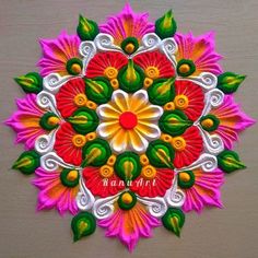 an intricately designed colorful flower on a wooden surface with the words happy diwali written below it