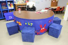 the children's table and stools are all made out of blue fabric with cartoon characters on them