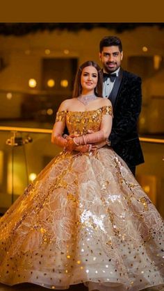 a man and woman in formal wear posing for a photo on the dancefloor