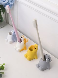 three toothbrush holders in the shape of elephants