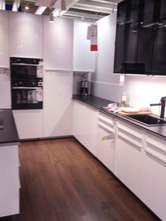 an empty kitchen with white cabinets and black counter tops is seen in this image from the front view