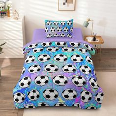 a bed with soccer balls on it and purple sheets