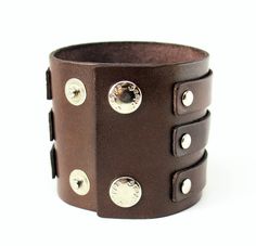 This is a MEDIUM SIZED, well decorated, handmade piece. The leather band is decorated with a 3 separate strips. This is another interesting piece of jewelry. This leather wristband changes width from very narrow to very wide as it encircles your wrist. Wear with double buckles facing out, or inward, to create different looks. Adjustable buckle closure will fit Men or Women. Stay fashionable and trendy with this handsome and sturdy leather bracelet. This men's jewelry item features a wide leather Leather Handcuffs, Biker Gifts, Leather Wristbands, Wrist Wear, Casual Jewelry, Well Decor, Leather Harness, Wrist Cuffs, Fit Men