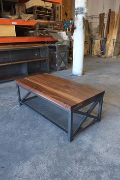 a wooden table sitting on top of a cement floor next to a pile of boxes