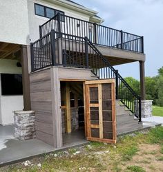 an outside view of a house with a balcony and stairs leading to the second floor