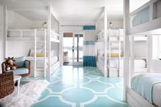 a bedroom with bunk beds and blue carpeted flooring in front of white walls