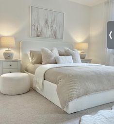 a bedroom with a large bed and white furniture