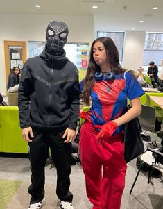 two people dressed up as spider man and woman in office setting with desks behind them