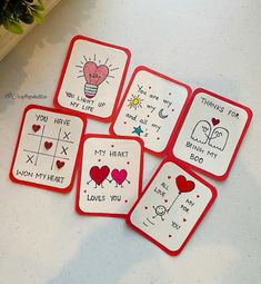 four red and white coasters with handwritten words on them sitting on a table