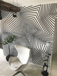 a white chair sitting in front of a black and white wall