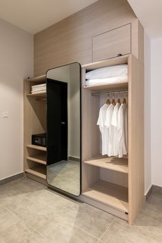 an open closet with clothes hanging on the shelves