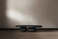 a black table sitting on top of a hard wood floor next to a white wall