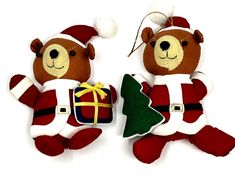 two teddy bears dressed as santa claus and holding a small christmas tree ornament