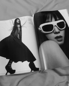 an open book with black and white photos on it's cover, featuring a woman wearing sunglasses