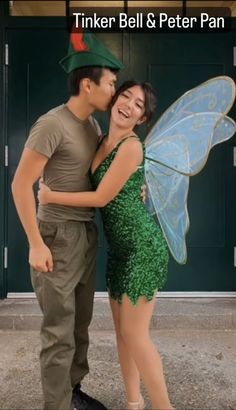 a man and woman dressed as tinkerbells pose for a photo in front of a green door