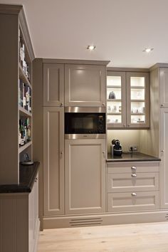 a kitchen with white cabinets and black counter tops in the center, along with an oven