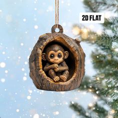 a wooden ornament hanging from a tree with snow falling around it and a small monkey in the hole