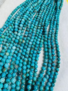 a long strand of turquoise beads on a white surface