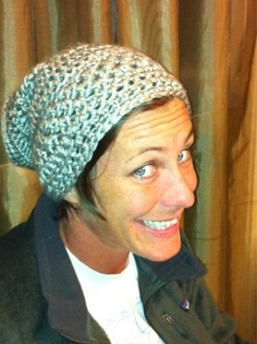 a smiling woman wearing a knitted hat