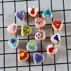 there are many small heart shaped cookies on the table with one cookie in the middle