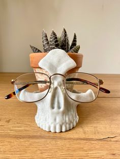 a skull wearing glasses sitting on top of a wooden table