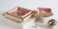 an open box containing two rings and some other items on a white surface with scissors