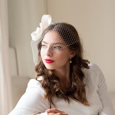 Understated, elegant bridal fascinator with netting birdcage veil stands for modern style bride. Looks great in custom colour for wedding guests or any other formal occasion.  The headpiece is elaborately hand-sewn of sinamay using traditional millinery technique. It is easy to place to any bridal hair style on side or to the bun, birdcage is removable.  The fascinator is on alligator clip, the veil on flat metal comb. Would you prefer skinny headband in your hair colour or hat elastic, just let me know. Pictured in white.  Also available in ivory, raspberry pink, poppy red, navy, black. Feather Headpiece, Bridal Fascinator, Birdcage Veil, Feather Wedding, Feather Fascinators, Wedding Fascinators, Bird Cage, Style Expert, Wedding Hair Accessories