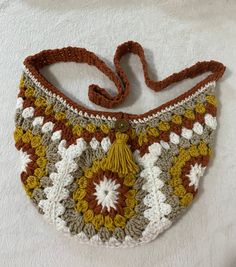 a crocheted purse sitting on top of a white blanket