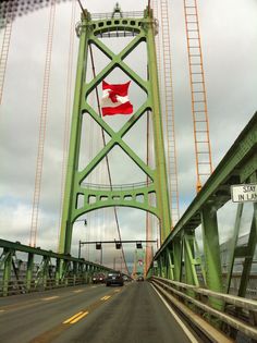 a green bridge that has a red flag on it